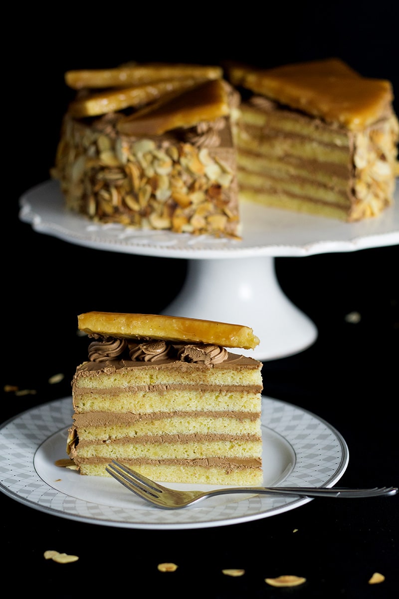 This amazing Hungarian layer cake called Dobos Torte has a fantastic buttery chocolate frosting and crazy caramel topping. Perfect for birthdays! #cake #hungary #chocolate #buttercream | cookingtheglobe.com