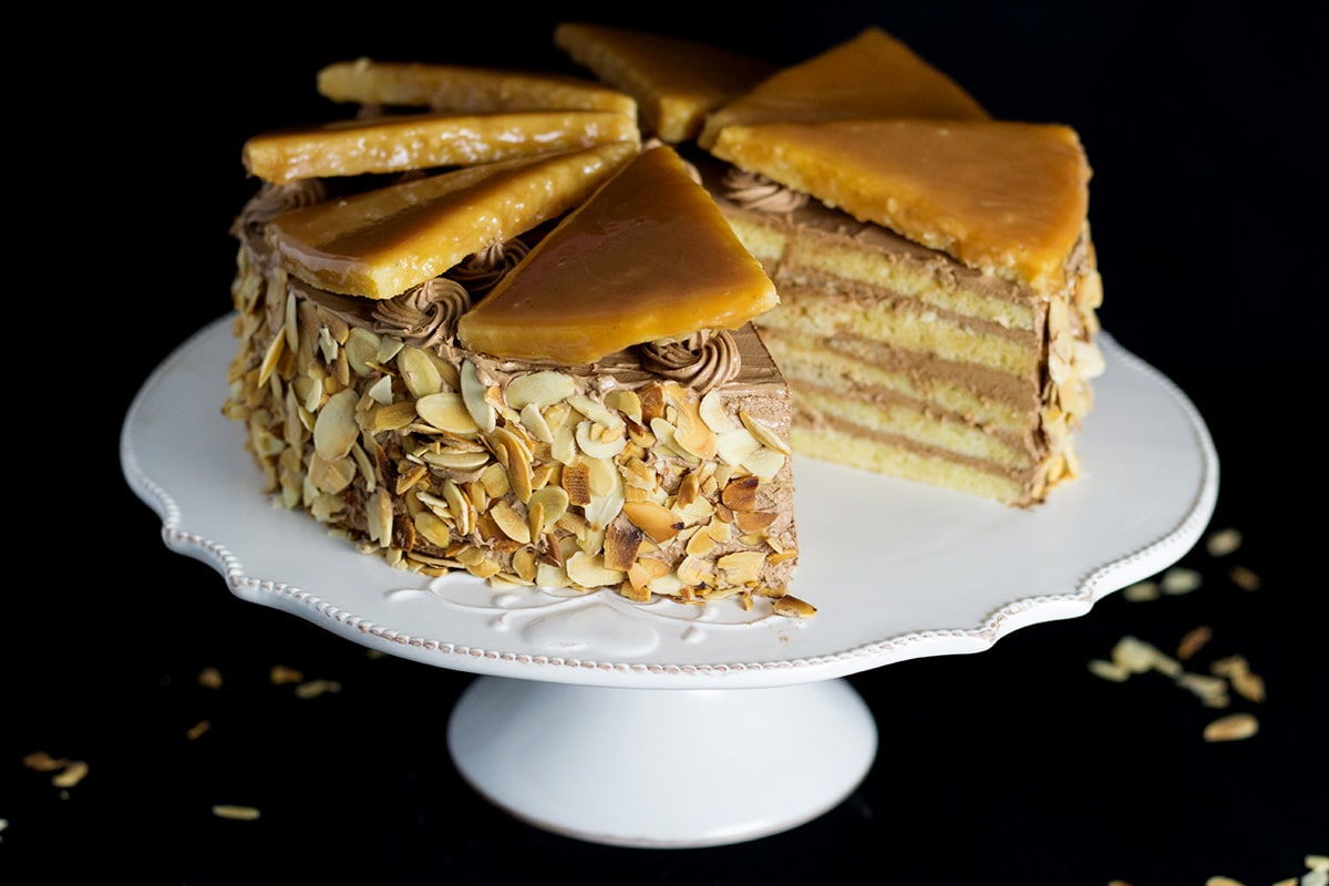 This amazing Hungarian layer cake called Dobos Torte has a fantastic buttery chocolate frosting and crazy caramel topping. Perfect for birthdays! #cake #hungary #chocolate #buttercream | cookingtheglobe.com