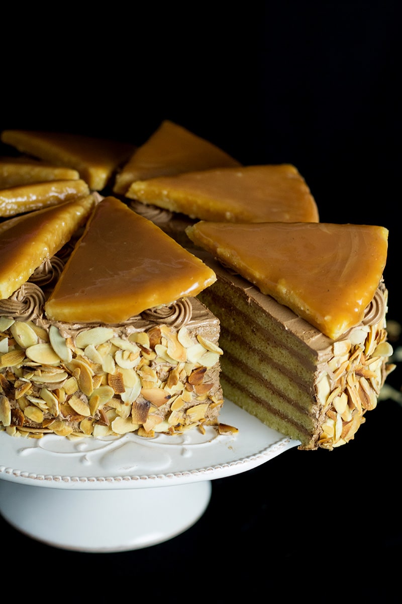 This amazing Hungarian layer cake called Dobos Torte has a fantastic buttery chocolate frosting and crazy caramel topping. Perfect for birthdays! #cake #hungary #chocolate #buttercream | cookingtheglobe.com