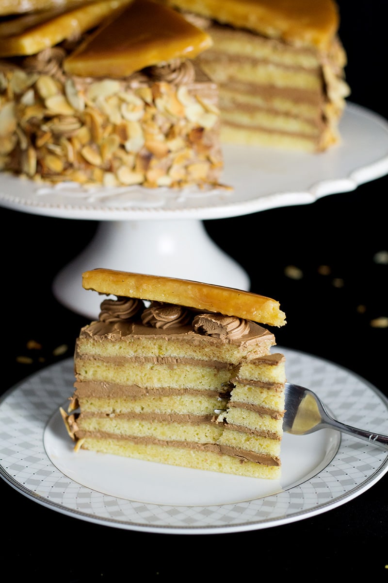 This amazing Hungarian layer cake called Dobos Torte has a fantastic buttery chocolate frosting and crazy caramel topping. Perfect for birthdays! #cake #hungary #chocolate #buttercream | cookingtheglobe.com