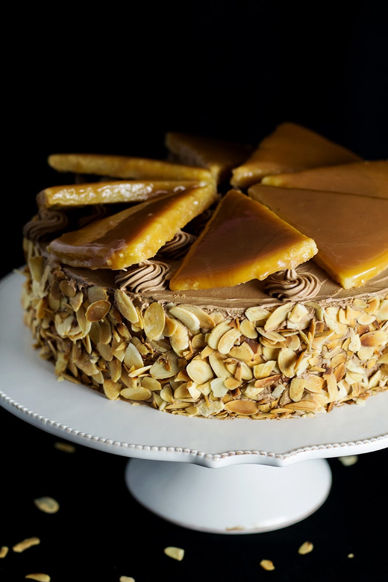 This amazing Hungarian layer cake called Dobos Torte has a fantastic buttery chocolate frosting and crazy caramel topping. Perfect for birthdays! #cake #hungary #chocolate #buttercream | cookingtheglobe.com