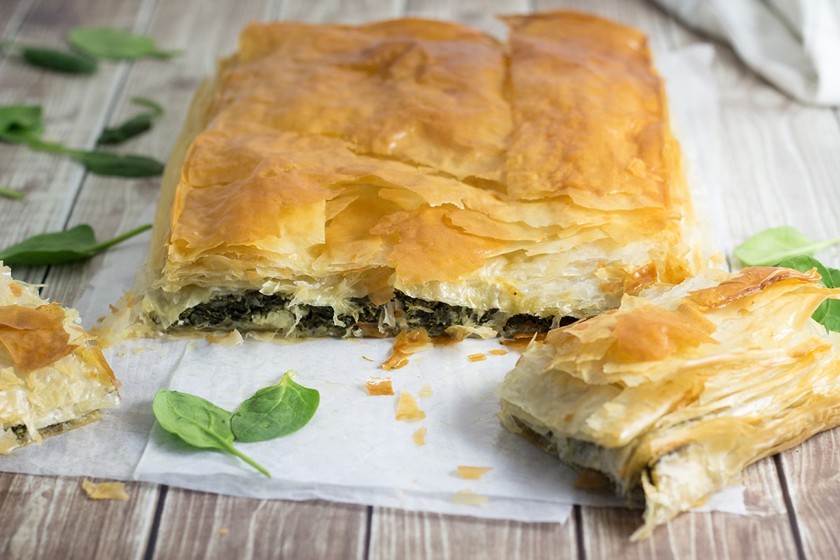 This delightful Greek spinach pie, called Spanakopita, is packed with spinach and feta cheese filling between flaky phyllo dough layers! | cookingtheglobe.com