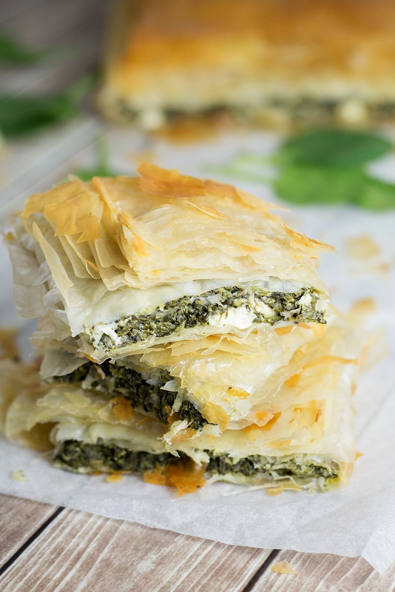 This delightful Greek spinach pie, called Spanakopita, is packed with spinach and feta cheese filling between flaky phyllo dough layers! | cookingtheglobe.com