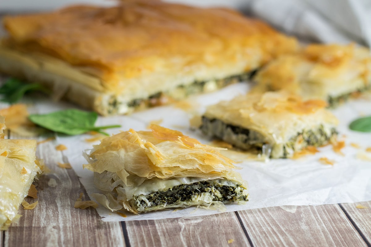 This delightful Greek spinach pie, called Spanakopita, is packed with spinach and feta cheese filling between flaky phyllo dough layers! | cookingtheglobe.com