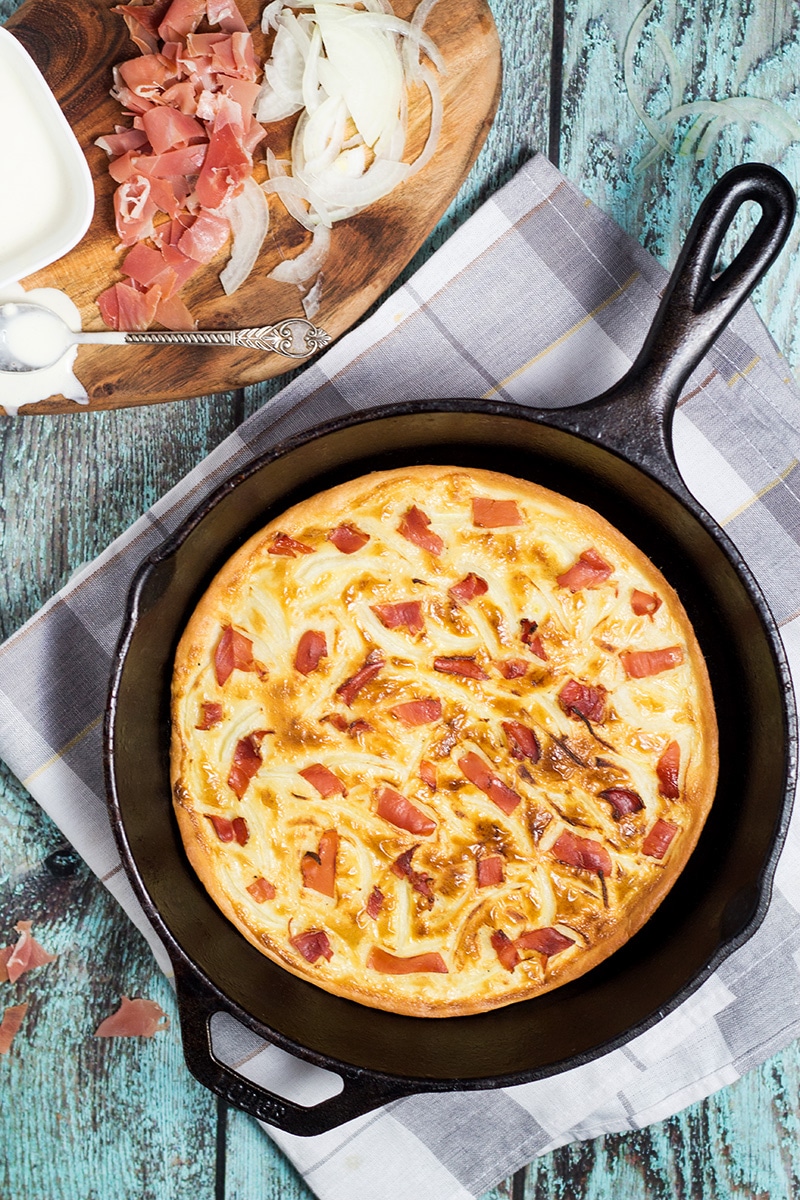 Tarte Flambee or Flammkuchen is a savory Alsatian pizza, topped with delicious sauce, onion and bacon! | cookingtheglobe.com