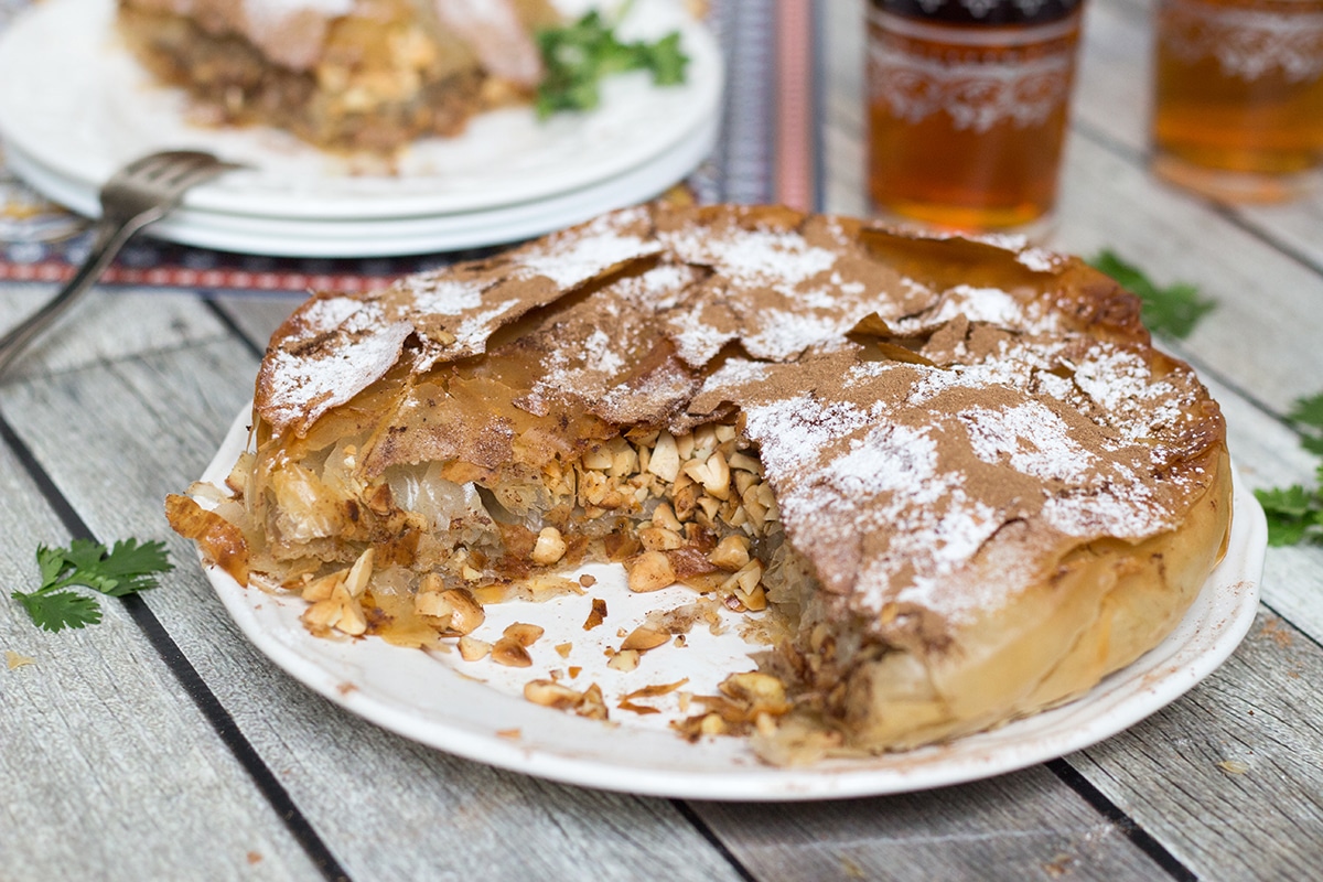 This sweet & savory Moroccan Pie (Pastilla) has a crisp, flaky pastry outside and an amazing cinnamon flavored chicken, onion, and almond filling inside!