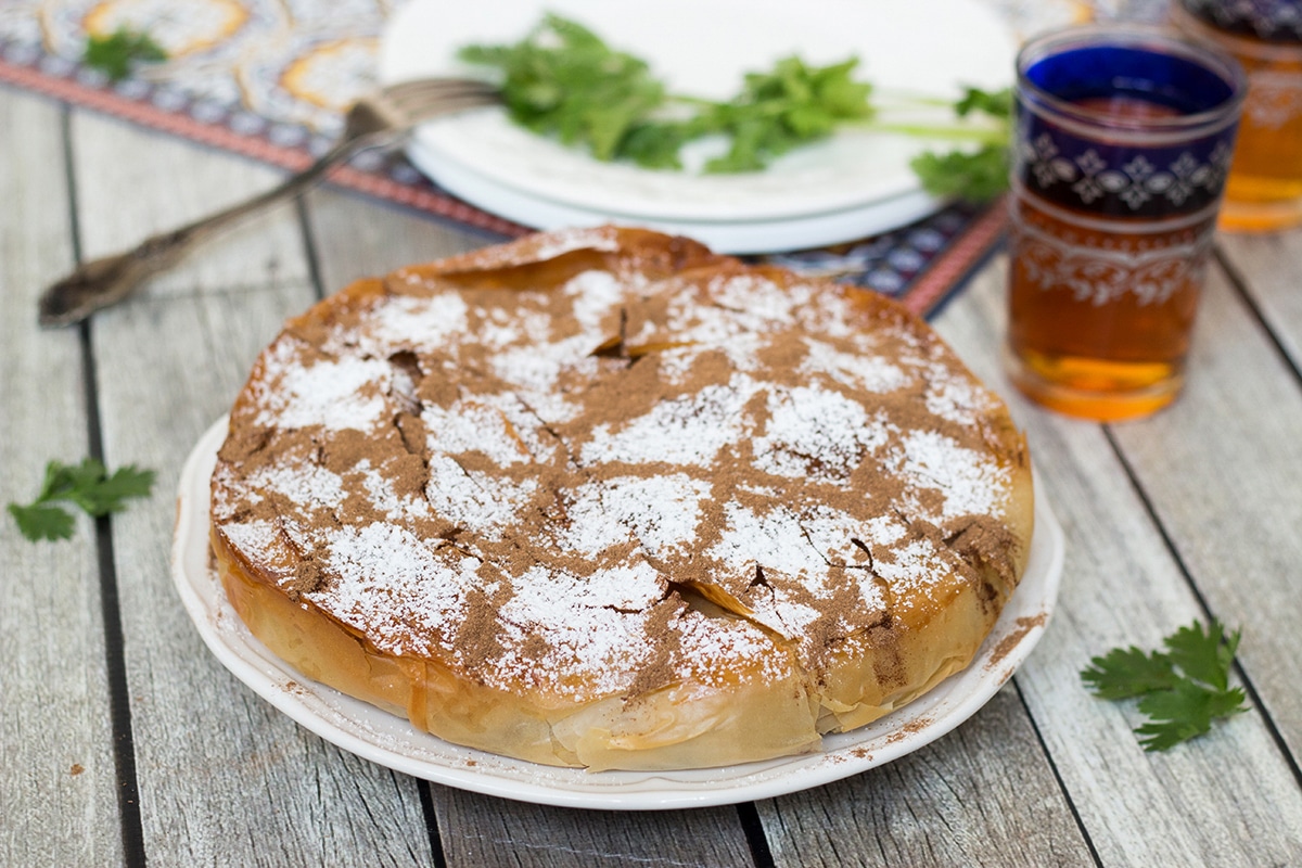 This sweet & savory Moroccan Pie (Pastilla) has a crisp, flaky pastry outside and an amazing cinnamon flavored chicken, onion, and almond filling inside!