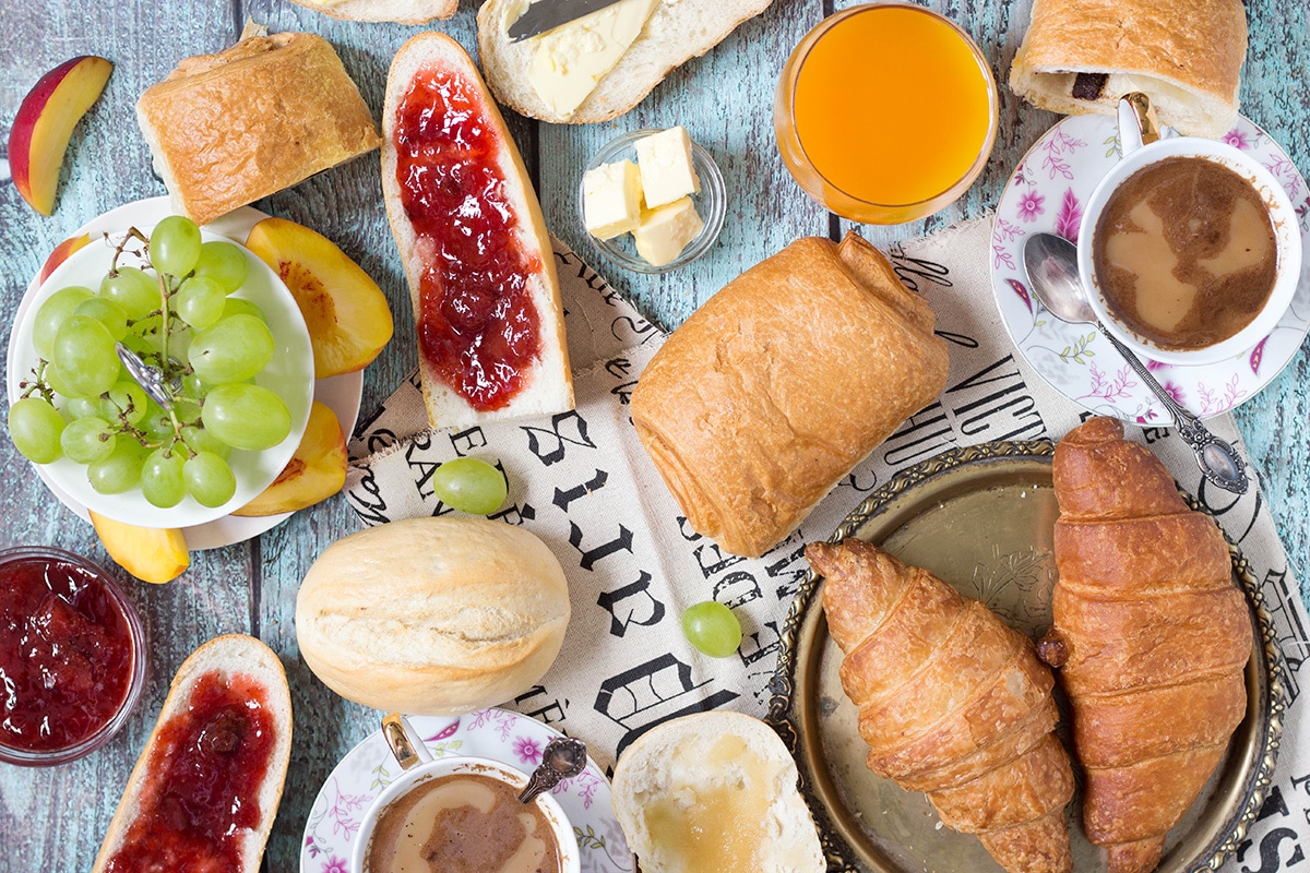 A look at the famous French breakfast, featuring a selection of breads and toppings, croissants, Pain au chocolat, and other goodies! | cookingtheglobe.com