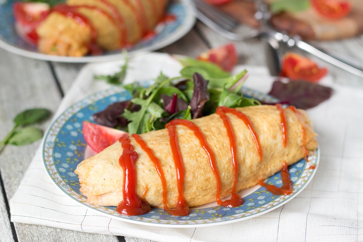 Omurice is a Japanese dish which got its name from a combo of words "omelette" and "rice". Basically, it's ketchup flavored rice cooked with chicken, peas, and wrapped in a thin crepe-like omelette. Pure heaven! | cookingtheglobe.com