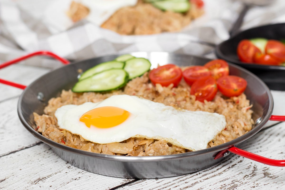 Indonesian Fried Rice (Nasi Goreng) is one of the most popular Indonesian dishes. It features chicken, tons of veggies, and is served with a fried egg on top! | cookingtheglobe.com