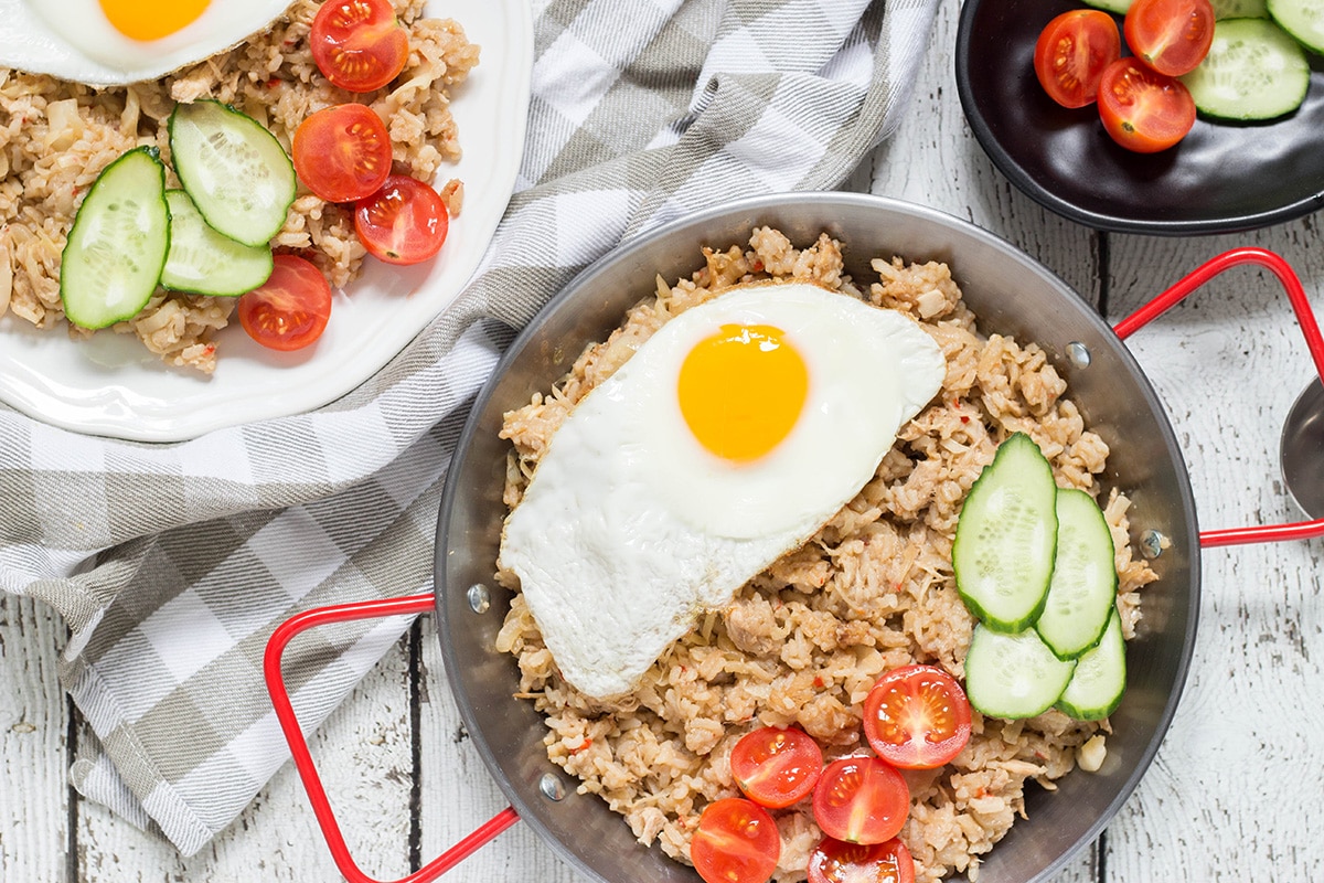 Indonesian Fried Rice (Nasi Goreng) is one of the most popular Indonesian dishes. It features chicken, tons of veggies, and is served with a fried egg on top! | cookingtheglobe.com