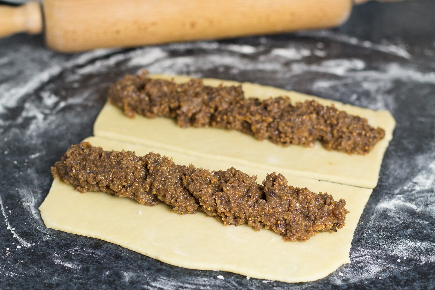 Questi biscotti natalizi italiani, chiamati anche Cuccidati, sono riempiti con un succulento composto di fichi e noci e conditi con una dolce glassa bianca! | cookingtheglobe.com