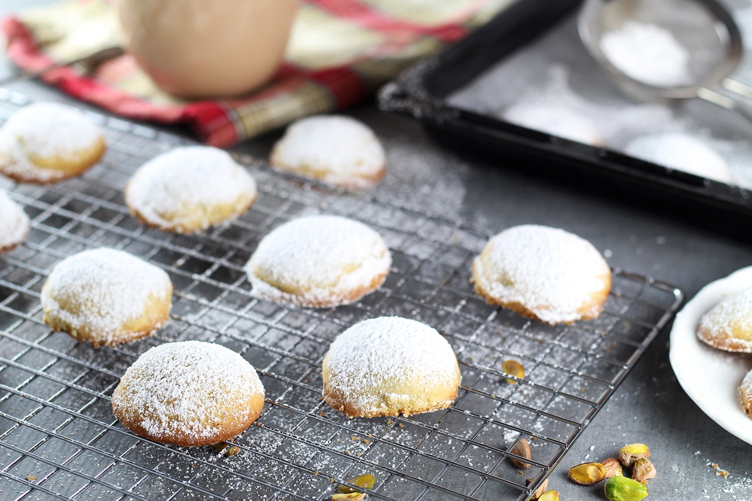 These Greek Butter Cookies (Kourabiedes) are usually made on Christmas or other holidays. They are tender, buttery, and stuffed with pistachios! | cookingtheglobe.com