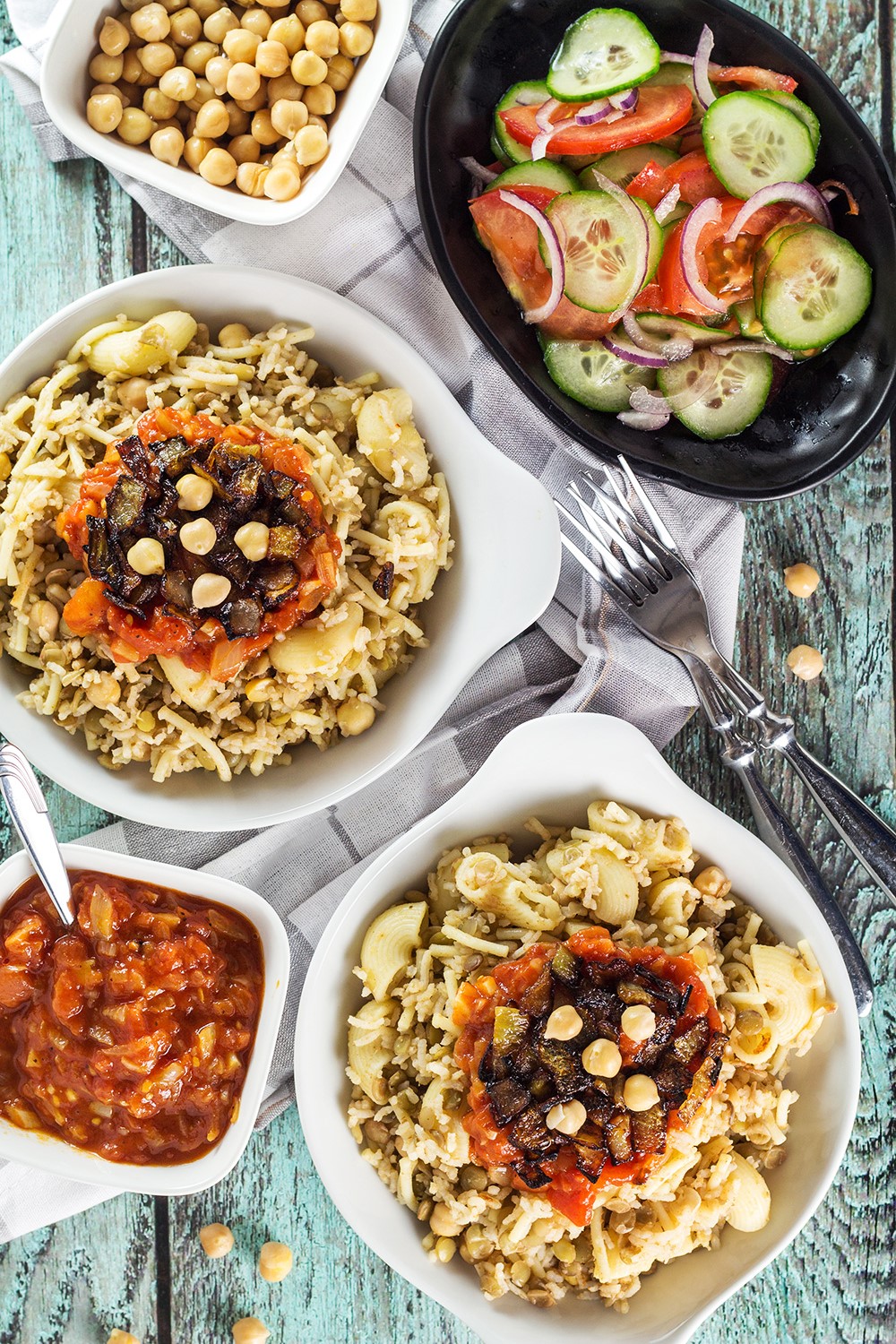 Koshari, or lentils and rice, is a national Egyptian dish. It also features pasta, chickpeas, fried onions, and a homemade tomato sauce. Healthy, filling, nutritious! #vegetarian #vegan| cookingtheglobe.com