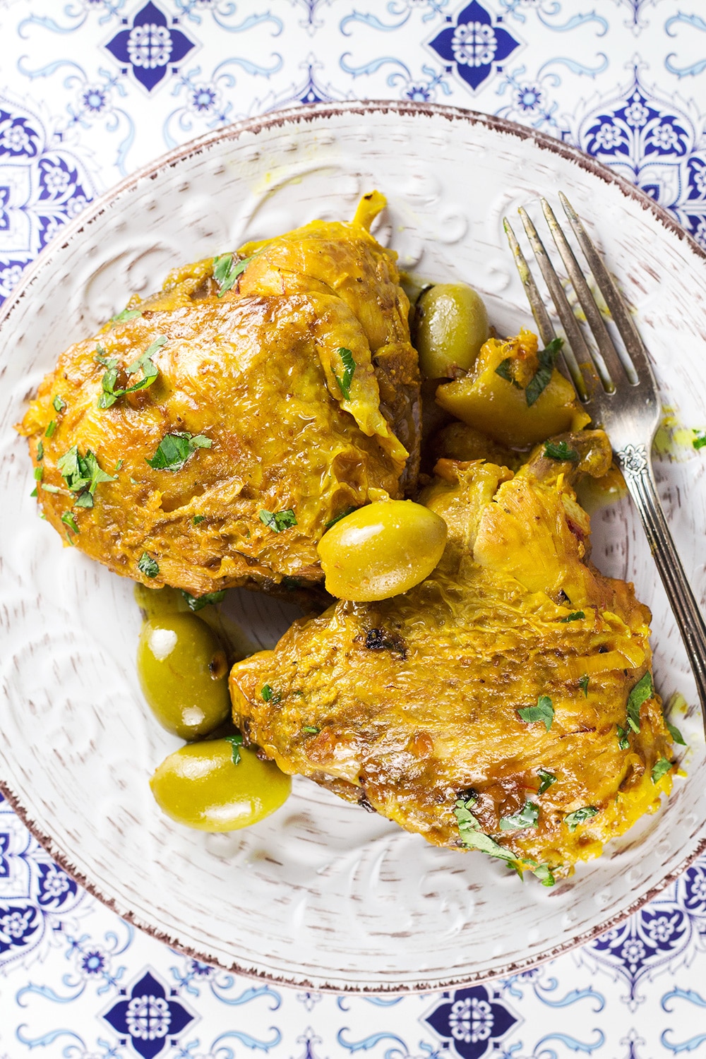 This Moroccan Chicken Tagine is bursting with flavor! Infused with saffron and flavored with preserved lemons, it's guaranteed to become your favorite! | cookingtheglobe.com