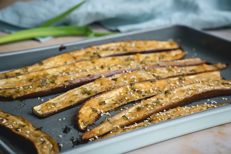 Nasu Dengaku sprinkled with sesame seeds on a baking sheet