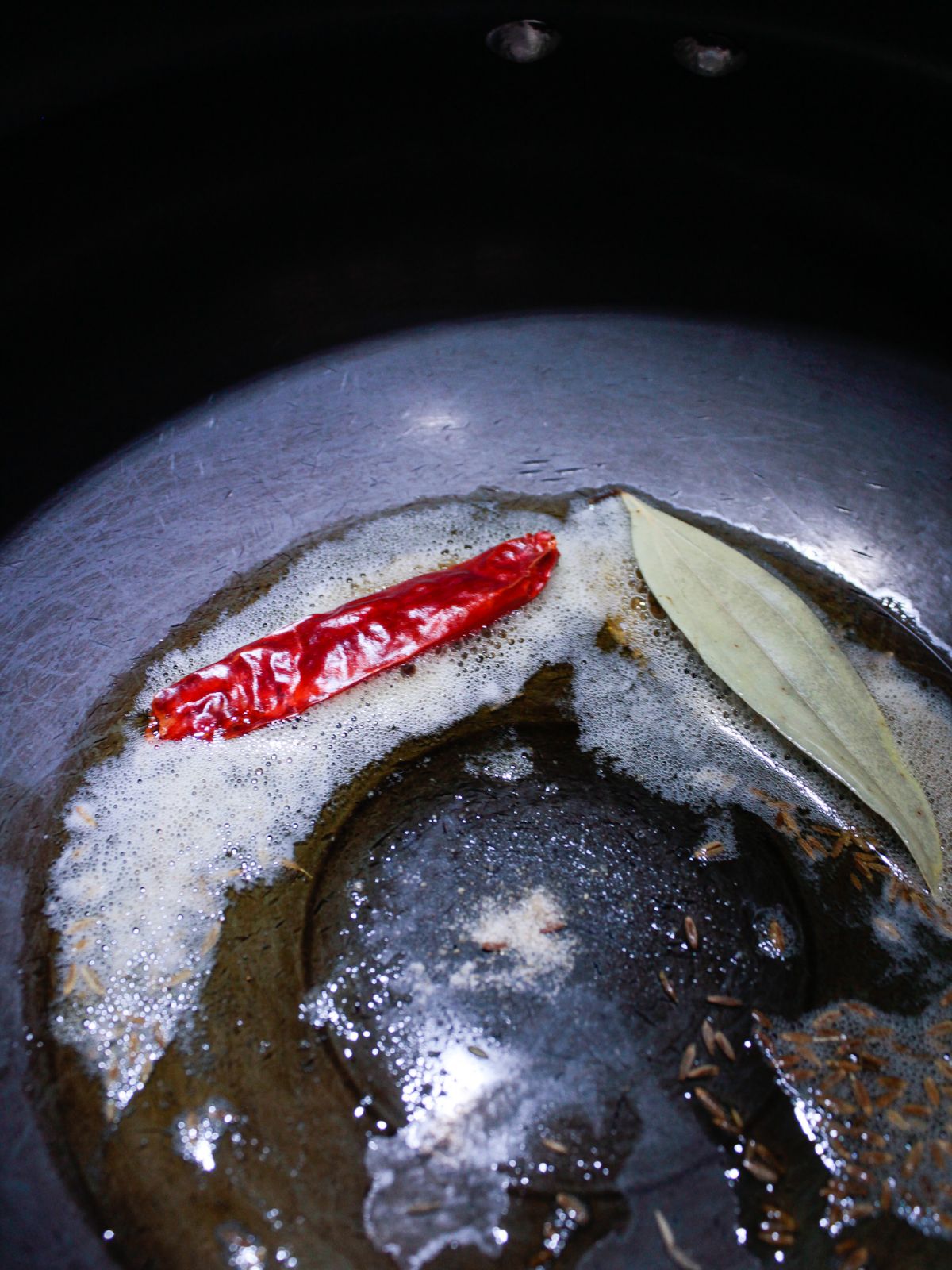 Skillet with ghee dry red pepper and bay leaf