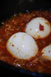 Hard boiled eggs in red curry in skillet