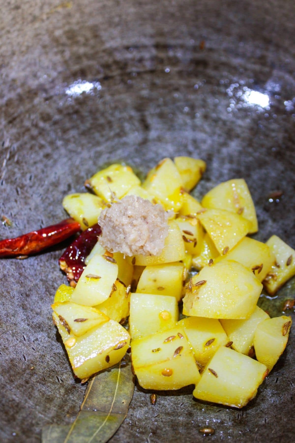 Potatoes and red chiles in skillet with ginger garlic paste