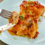 Fork and knife holding up bite of cabbage roll