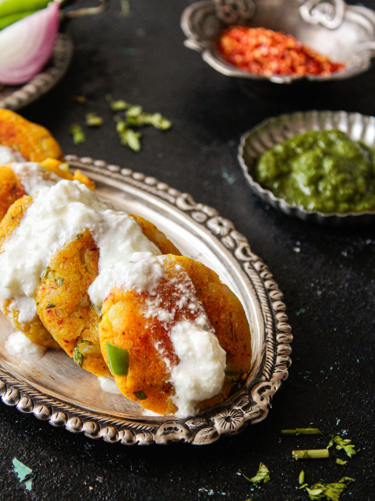 Plate of aloo tikki with curd on top