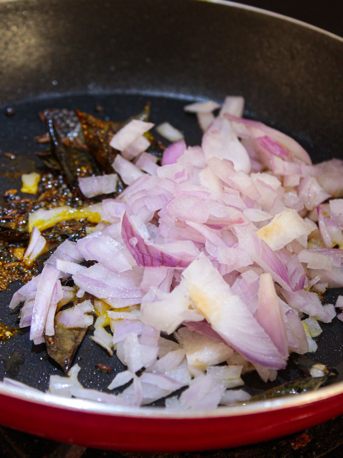 Red onions stacked in center of skillet