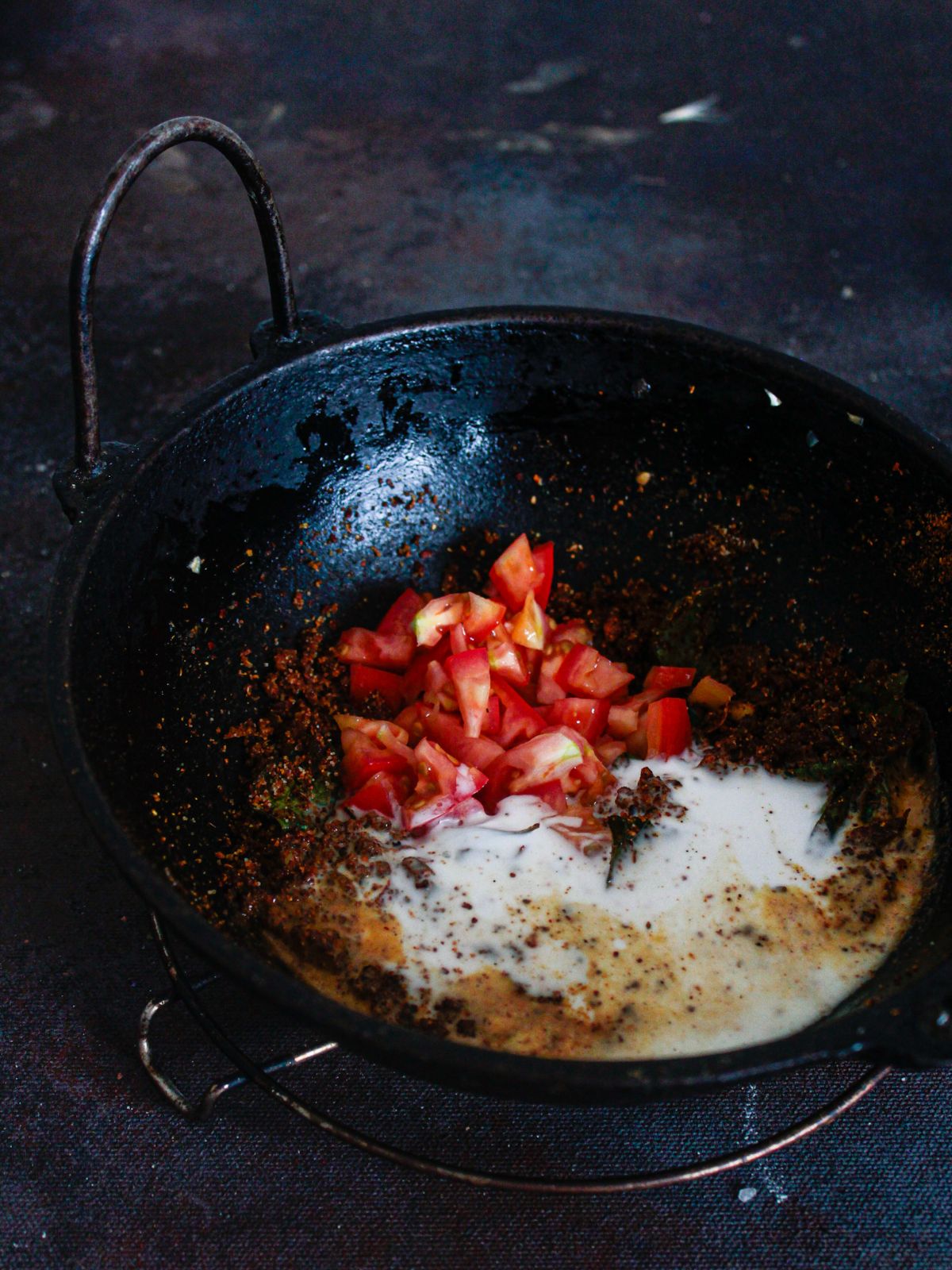 tomatoes and milk in wok with spices