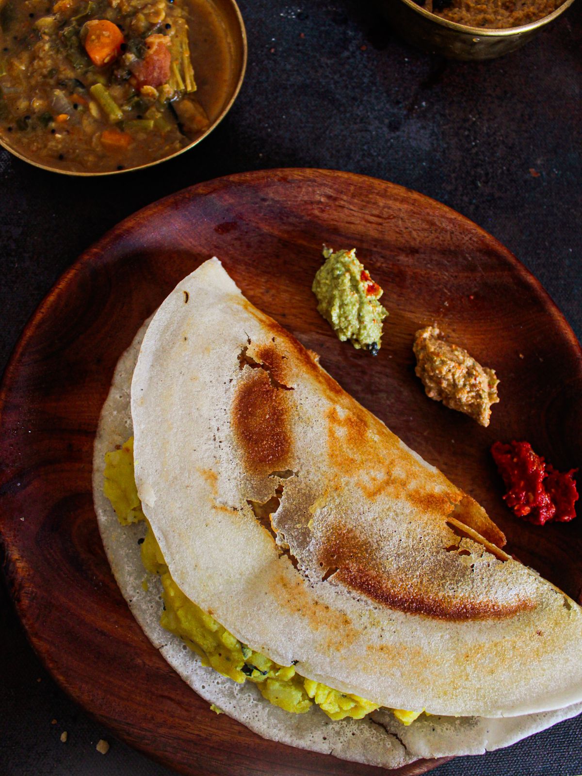 Masala Dosa Served with chutneys on wooden plate