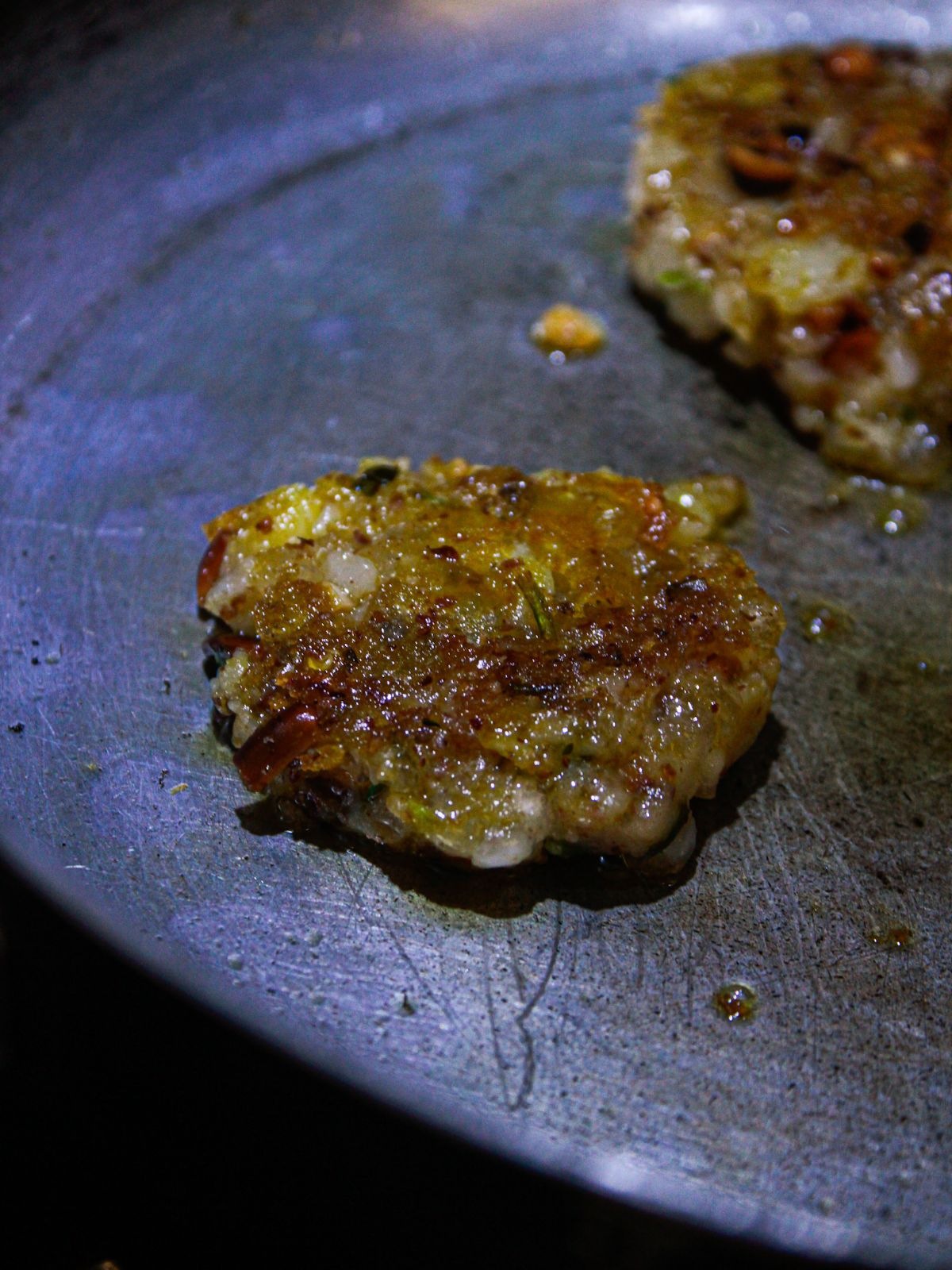 Tapioca fritter in skillet browned on one side