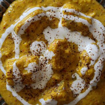 Indian Shahi Paneer with cream on top in large bowl