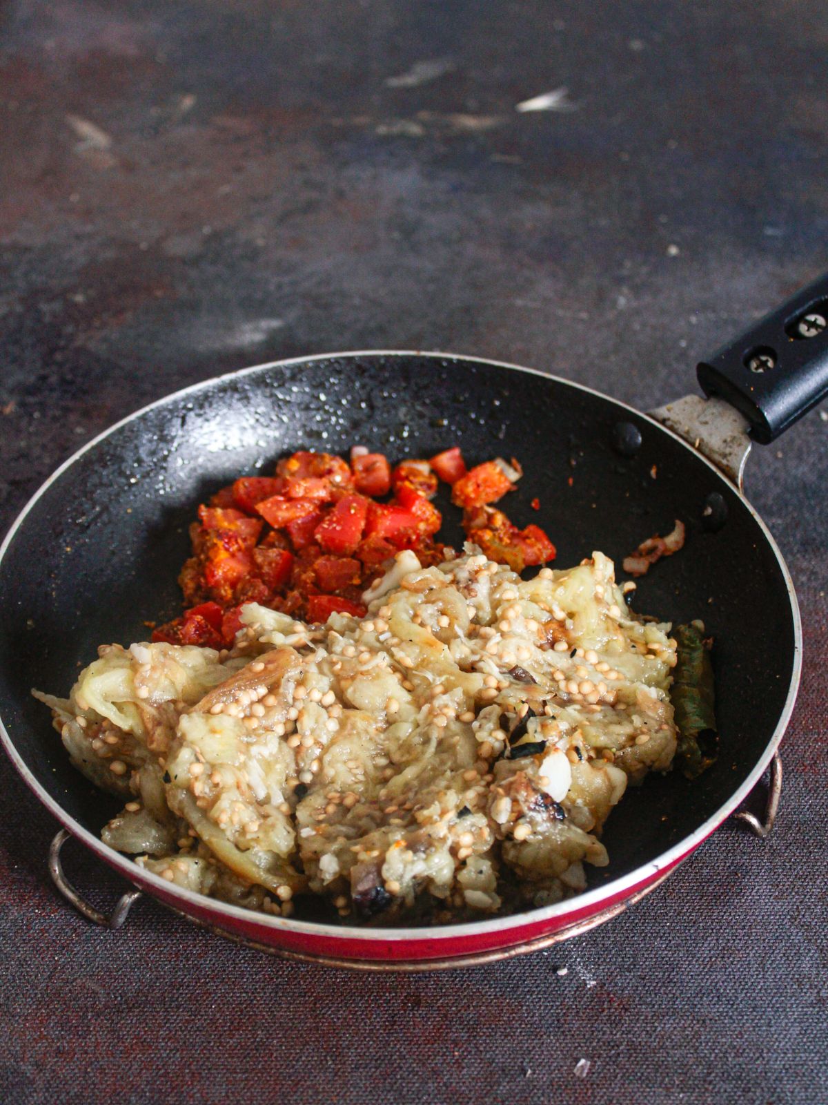 Eggplant mash in skillet with tomatoes