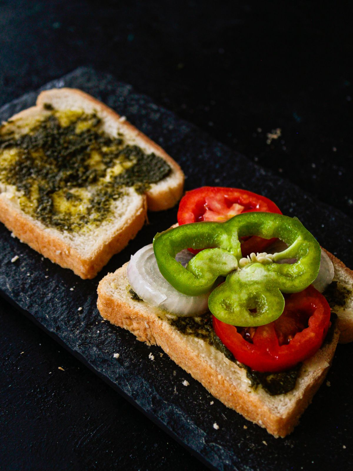 green pepper ring on top of tomato on sandwich slices