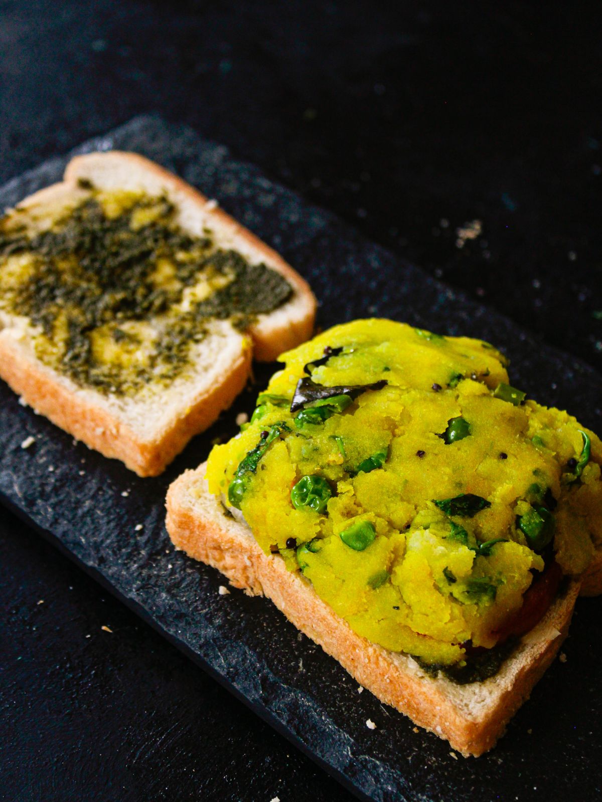 potato masala on top of one slice of bread next to bread with green chutney
