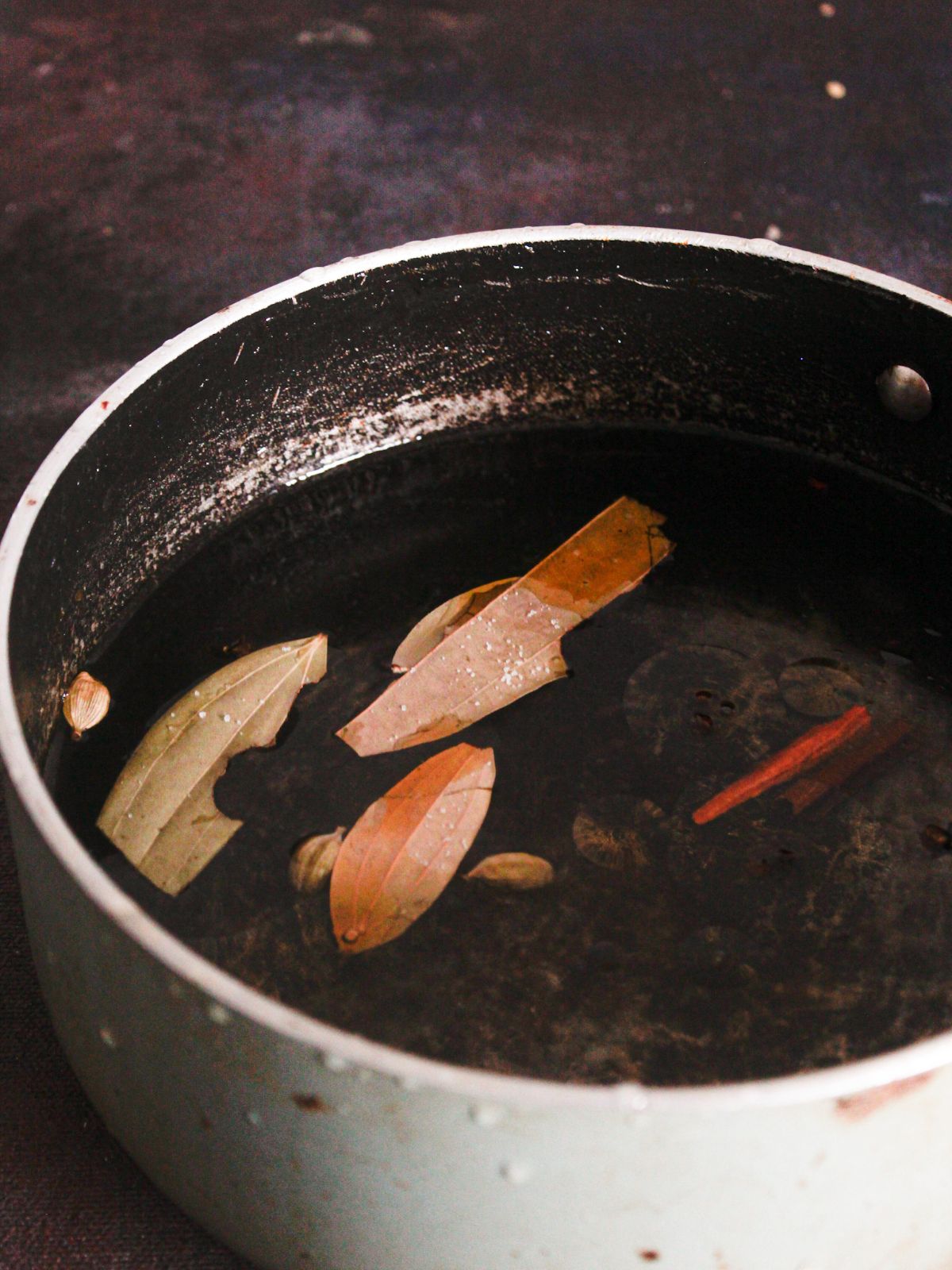 stockpot of water with bay leaf and cinnamon sticks