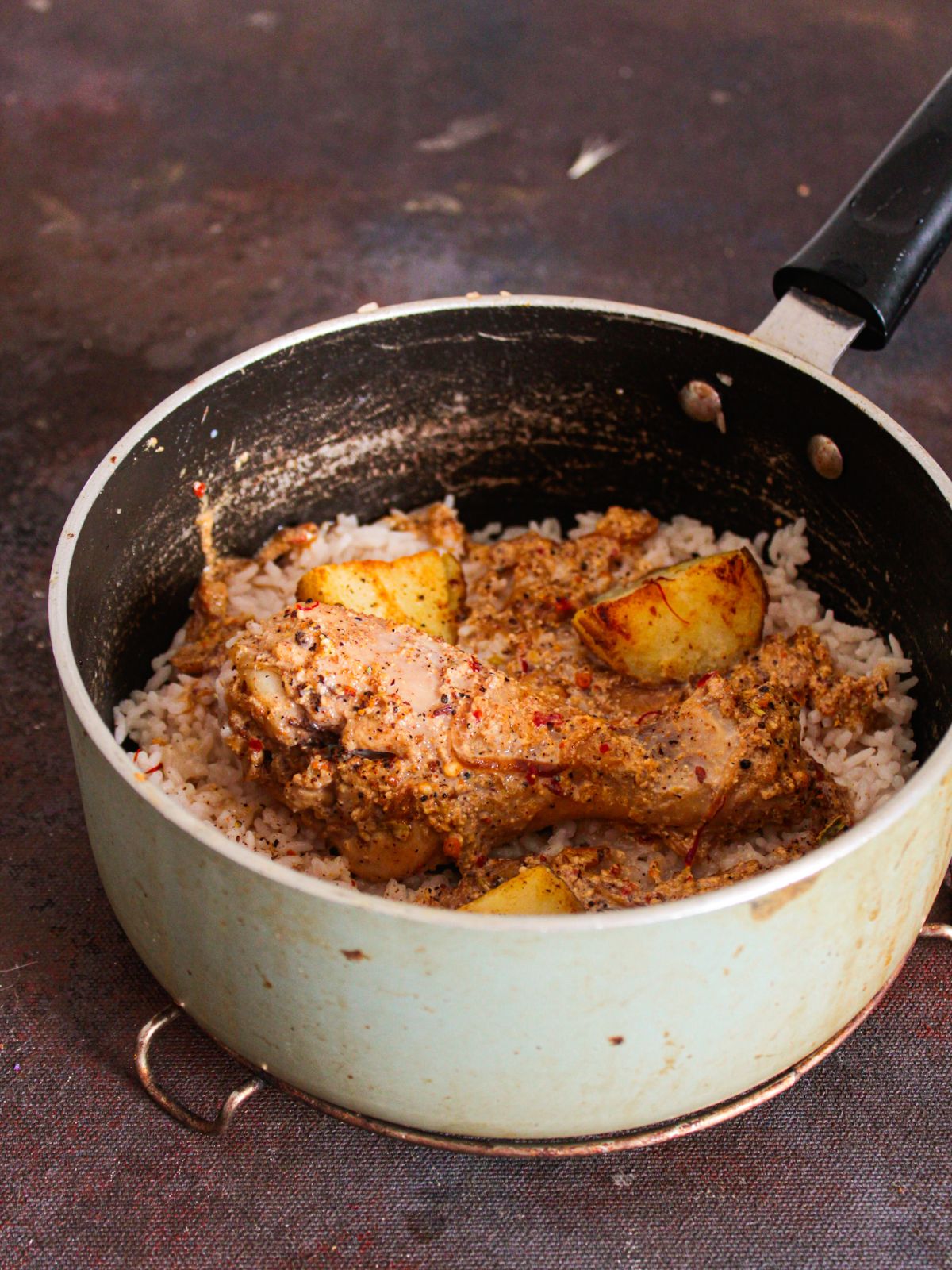 potato and chicken on rice in saucepan