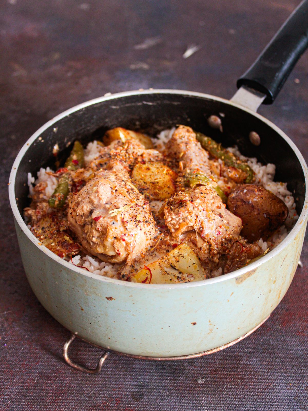 chicken legs on top of rice in saucepan