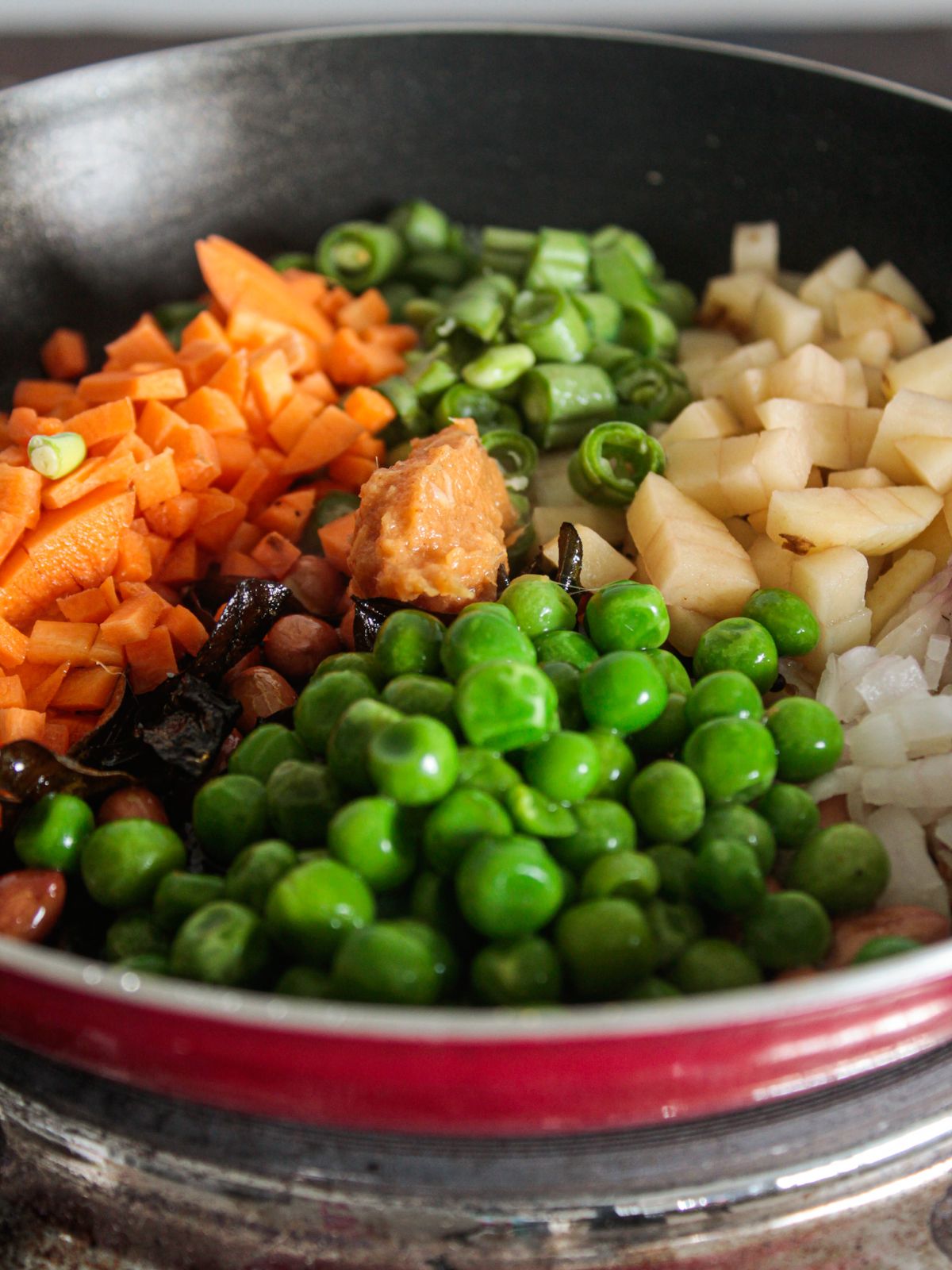 carrots peas and potatoes in red skillet