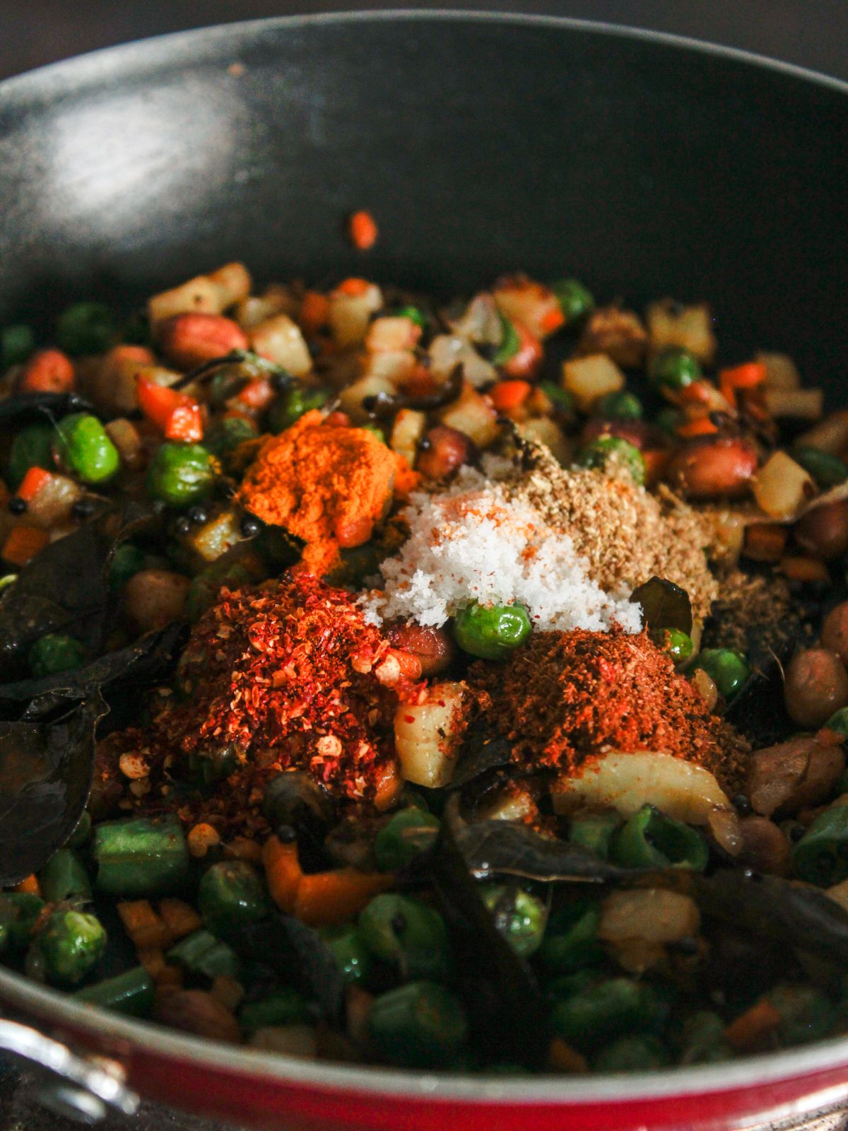 cooked vegetables in skillet topped with spices