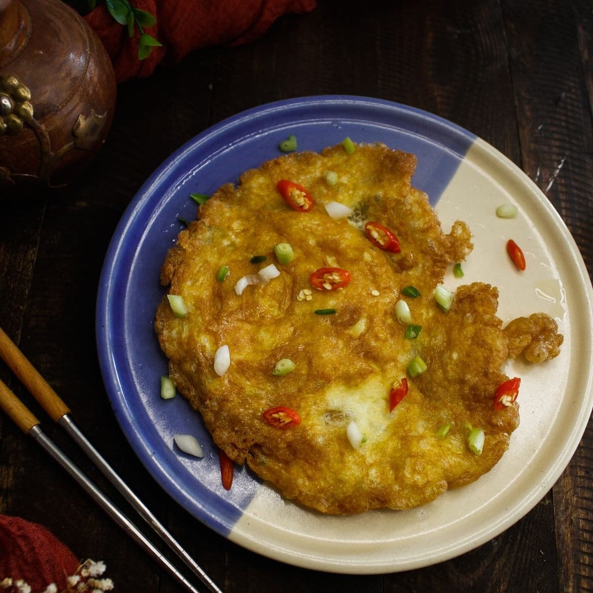 omelet on blue plate with green chili on top