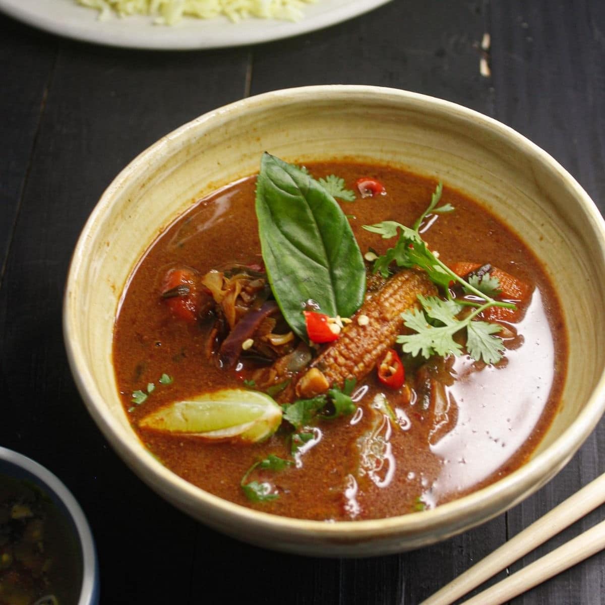 red curry in cream bowl on black table