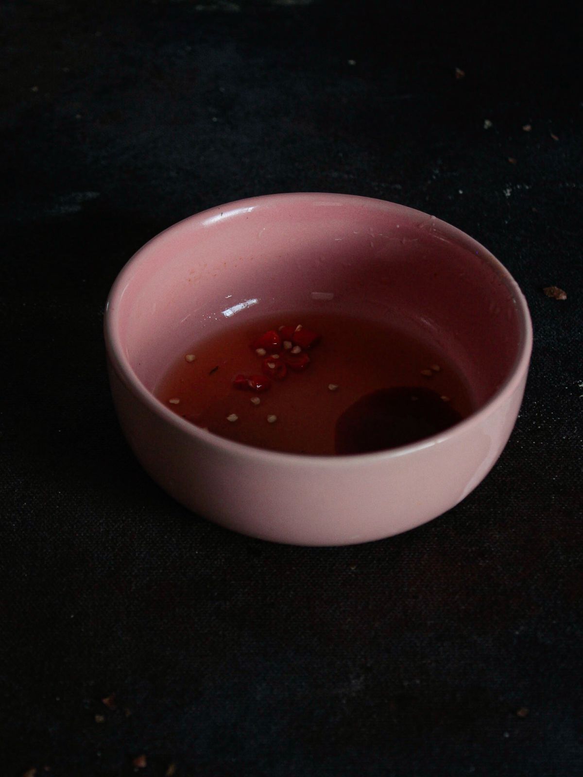 dipping sauce in pink bowl on black surface
