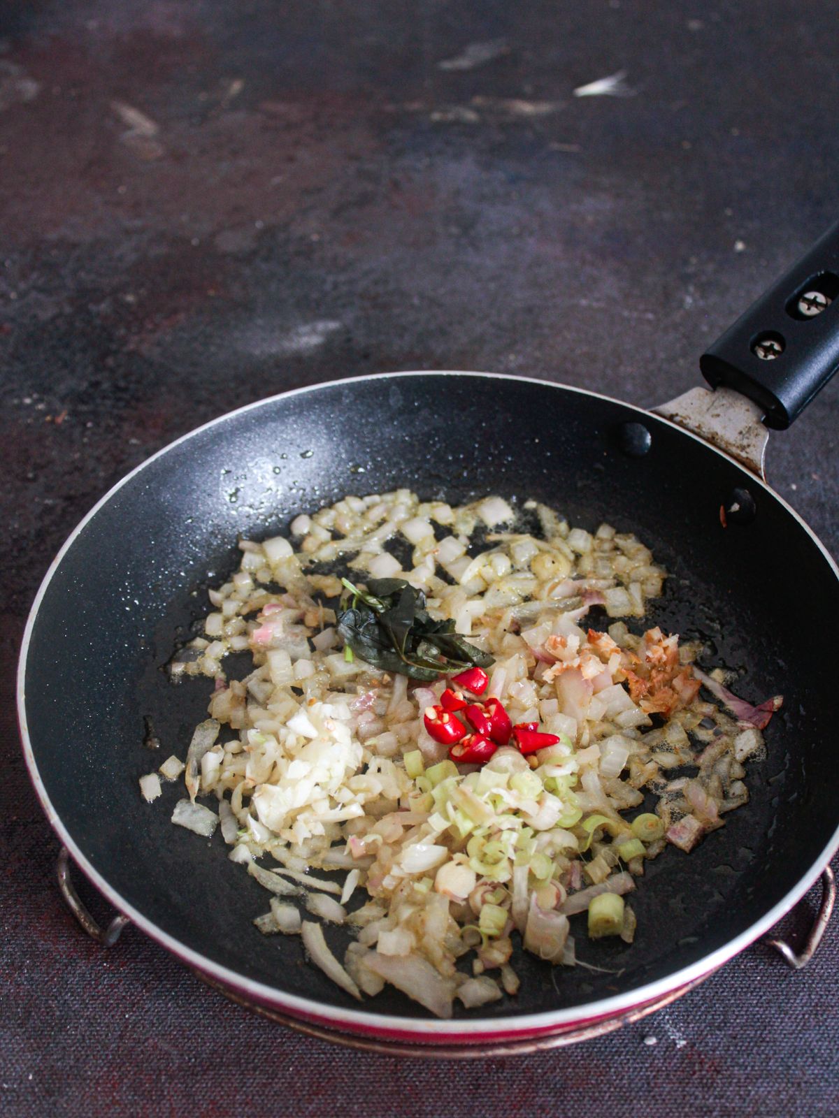 onions and chiles in skillet on gray table