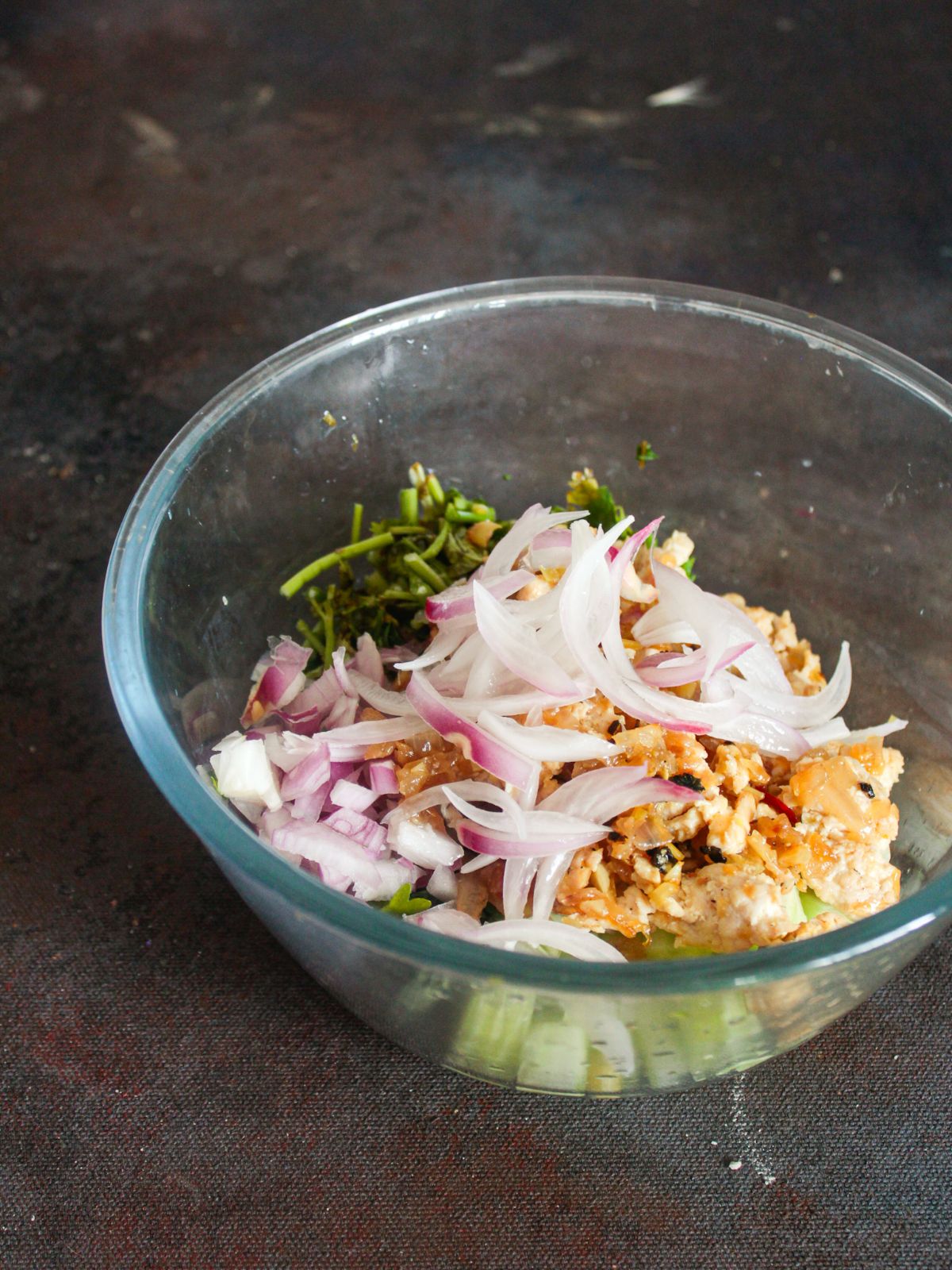 chicken vegetables and onions in large glass bowl