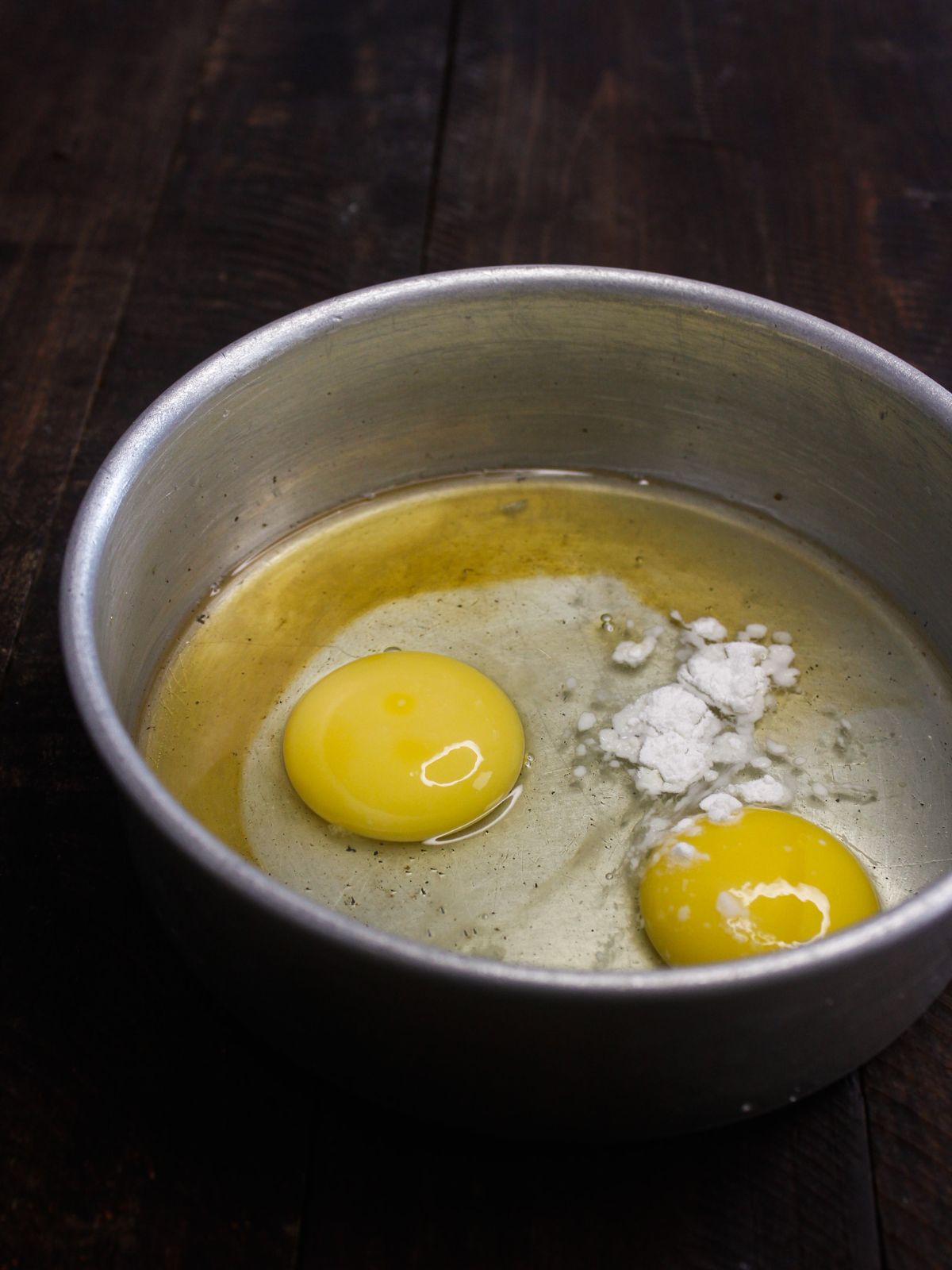 whole eggs cracked in metal bowl