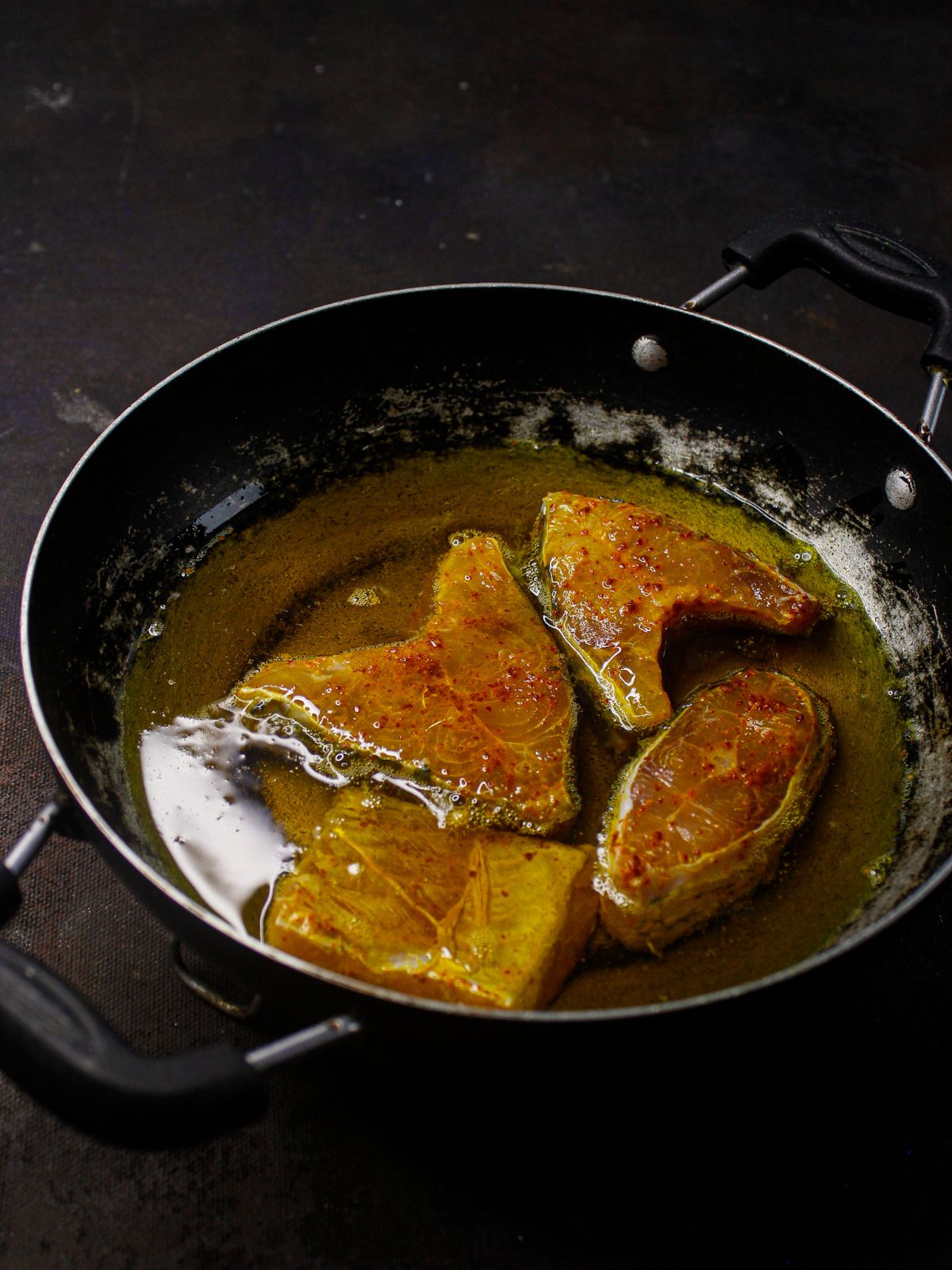 four pieces of fish in hot oil in skillet