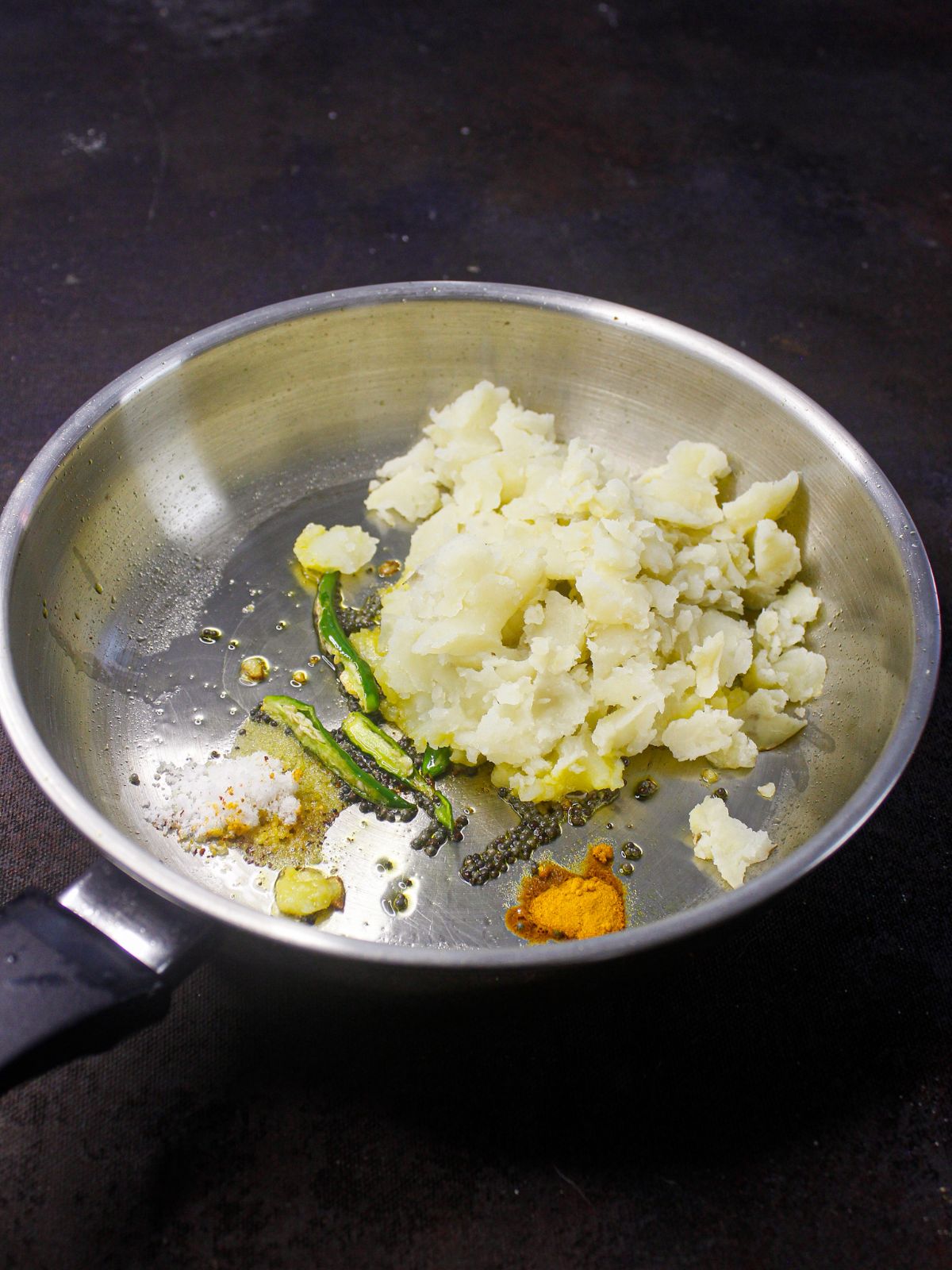 potatoes in skillet with oil and herbs