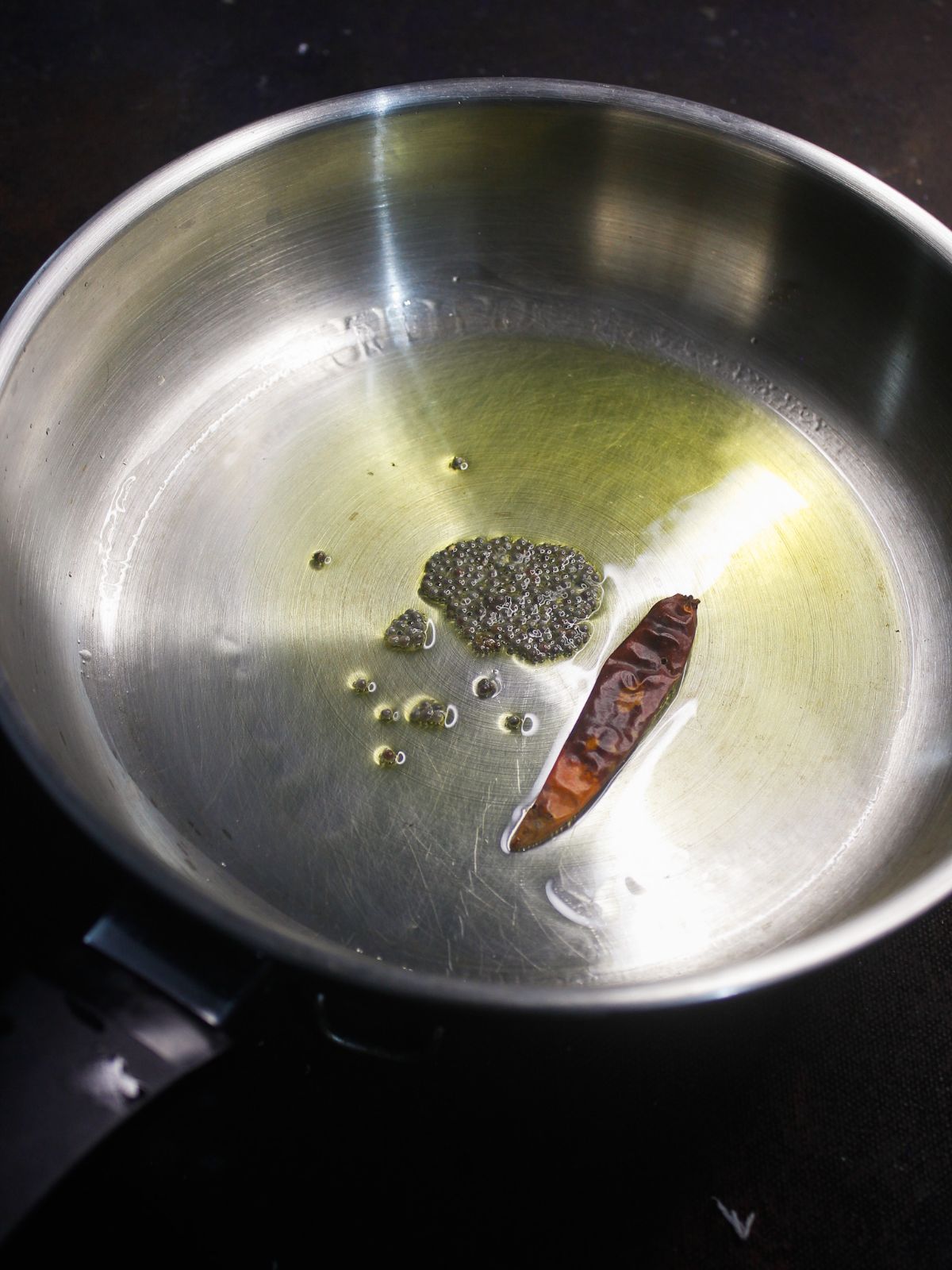 oil with dry chile and seeds in skillet