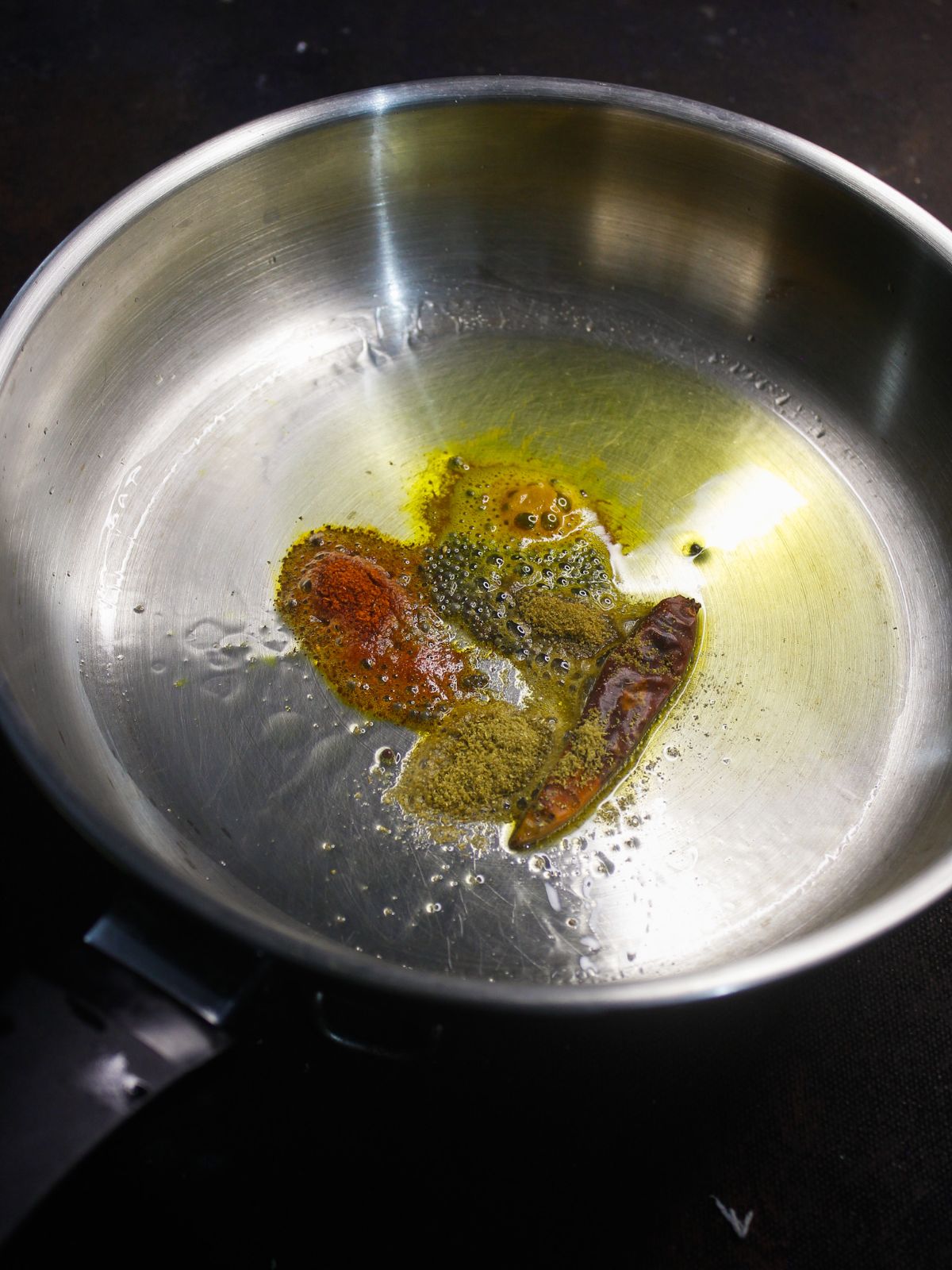 spices in oil in skillet