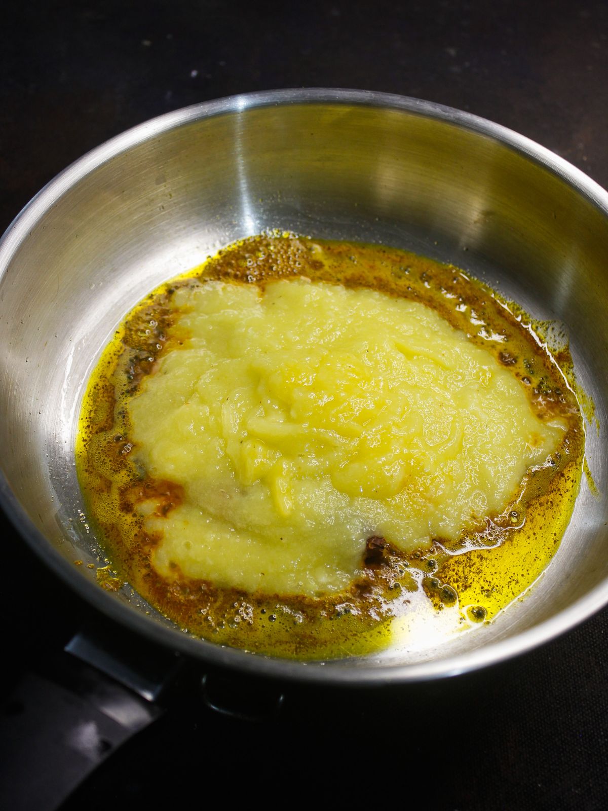 dal poured into skillet with oil