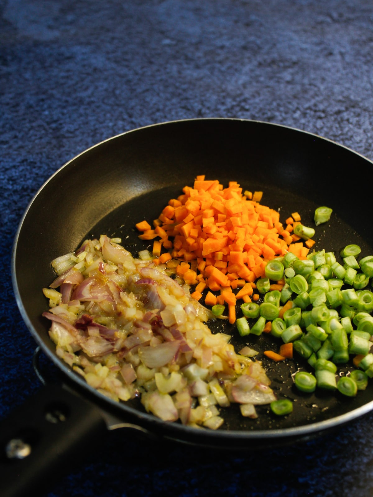 Add chopped carrots and peas to the pan and saute